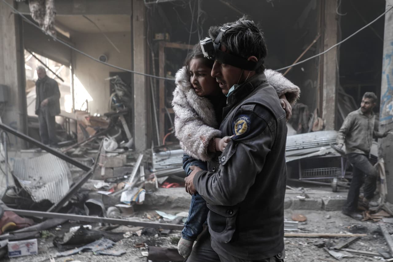 Un rescatista lleva a una niña herida, luego de un bombardeo sobre la ciudad de Douma, cerca de Damasco. 25 de febrero de 2017.