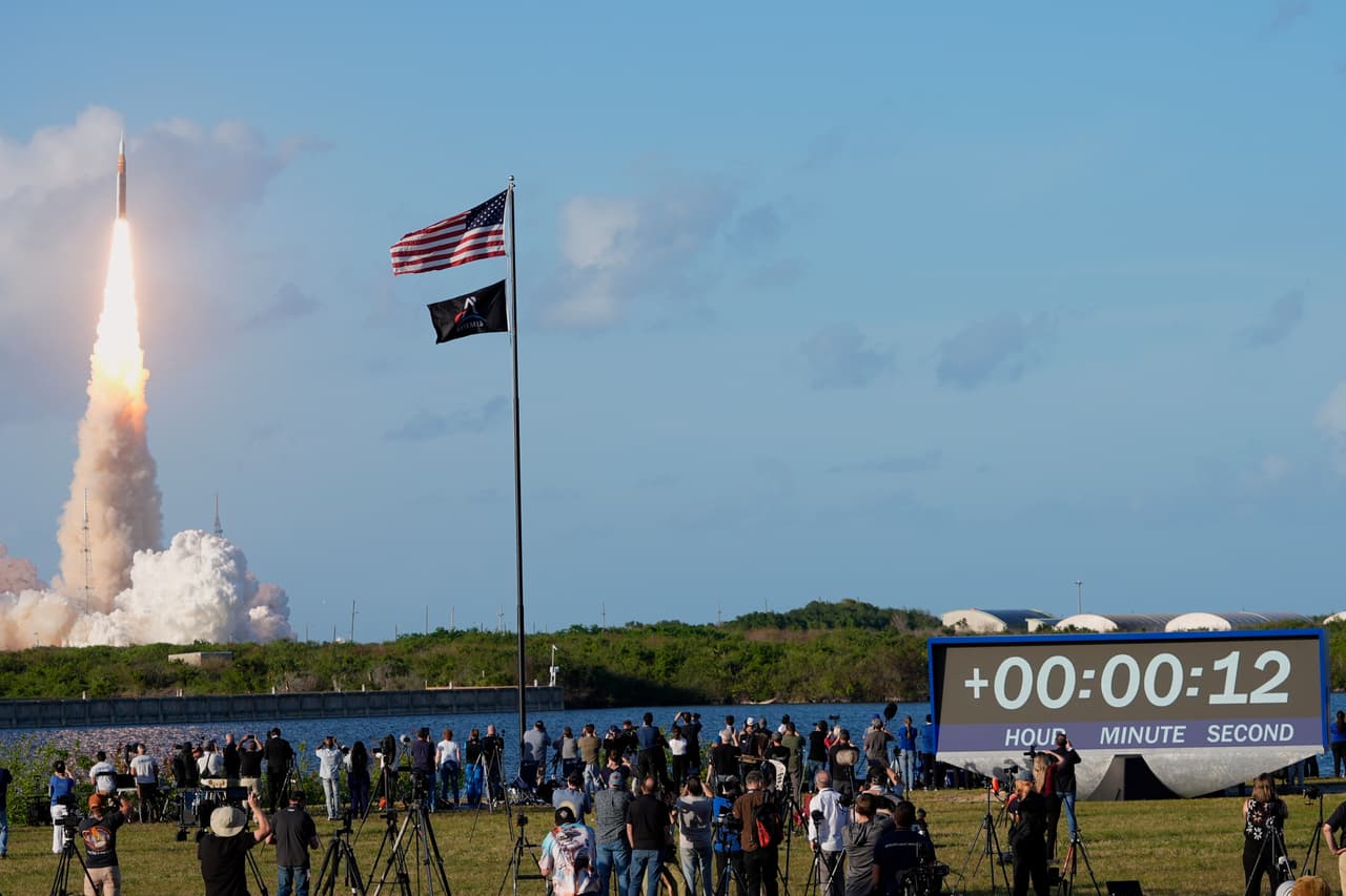 Varias personas observan el despegue del cohete lunar Artemis II de la NASA desde la plataforma de lanzamiento 39-B del Centro Espacial Kennedy. (Foto AP/John Raoux)
