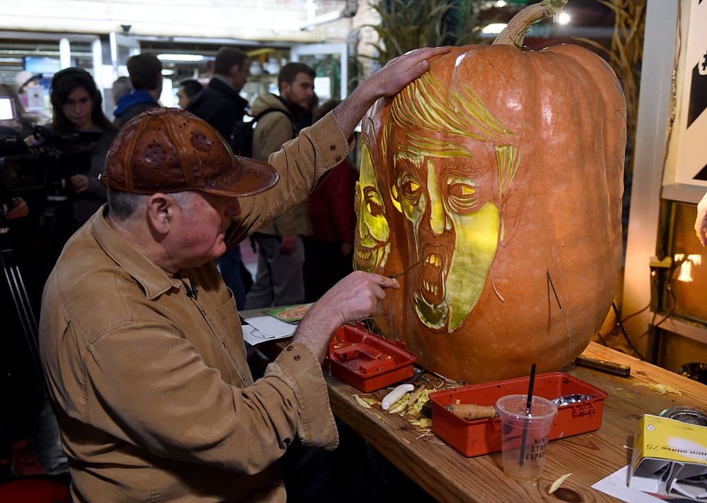 El escultor Hugh McMahon mientras talla en dos grandes calabazas los rostros de Clinton y Trump en víspera de las elecciones presidenciales y de la celebración de Halloween.