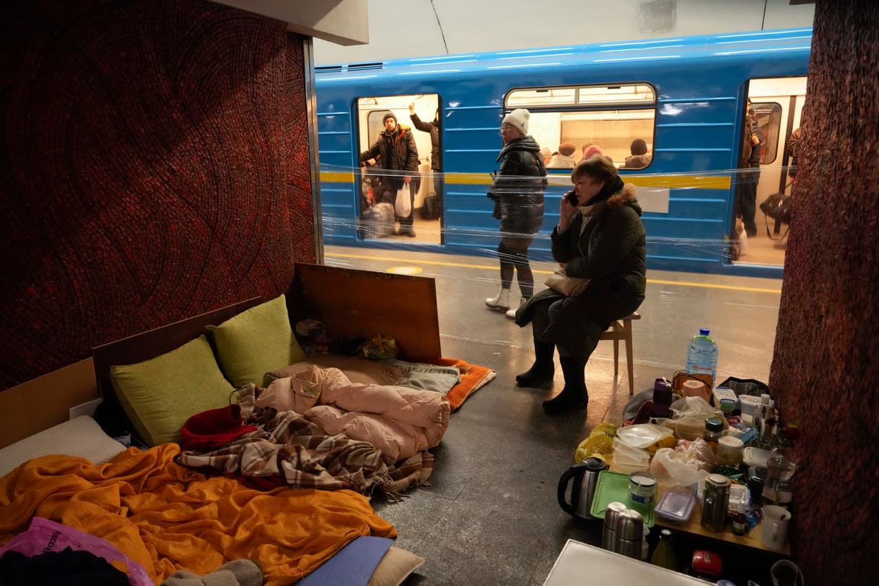 Una mujer, junto con sus pertenencias y algo de comida, sentada en un refugio improvisado en una estación de metro de Kiev. Los combates alrededor de la capital ucraniana también se intensificaron, con bombardeos durante la noche en los suburbios del noroeste y un ataque con misiles el domingo que destruyó un almacén al este de la ciudad.