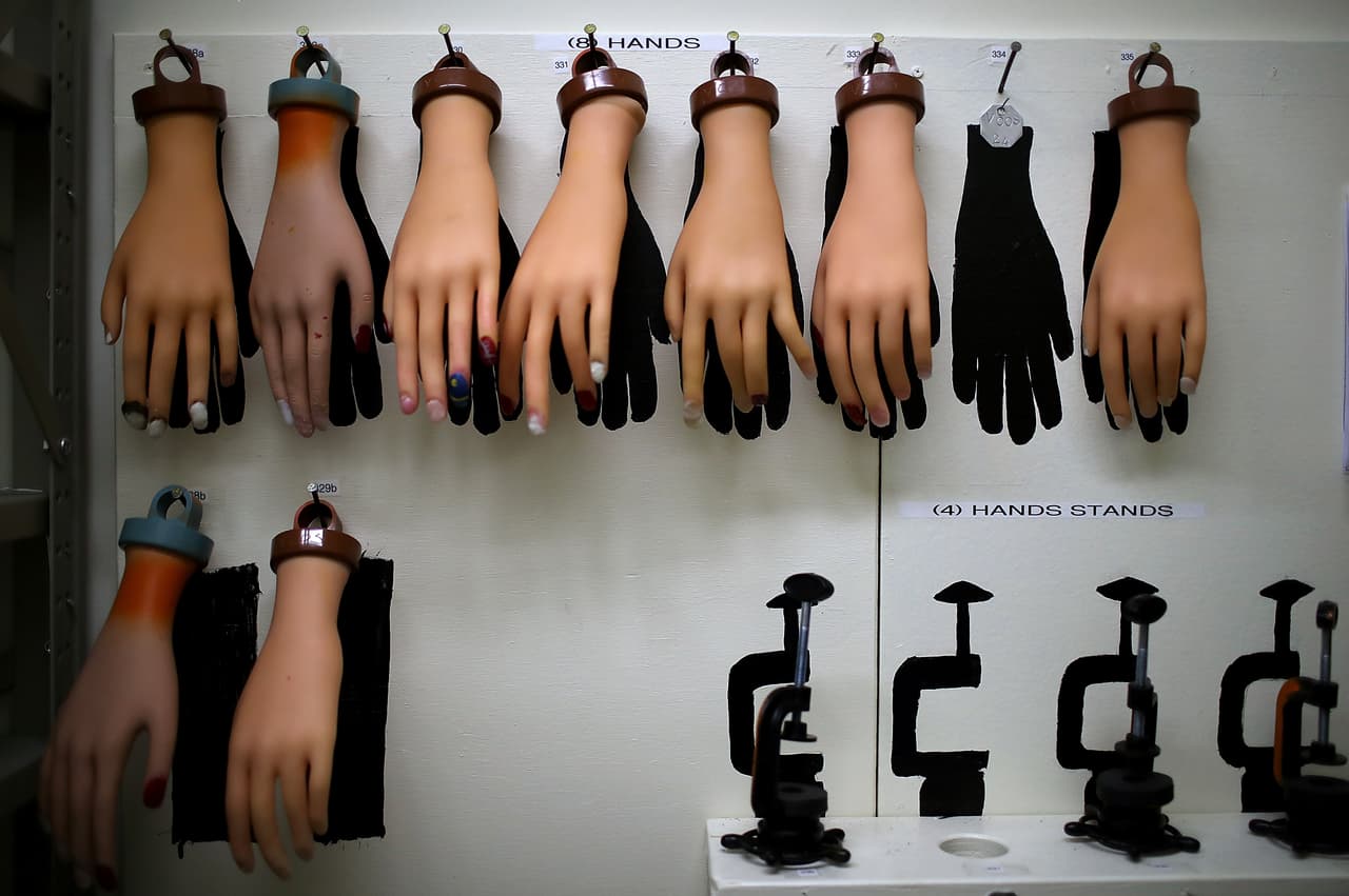 Manos de maniquí usadas para practicar se cuelgan en una pared del cuarto de equipos durante la clase de cosmetología de la Prisión de Valley State.