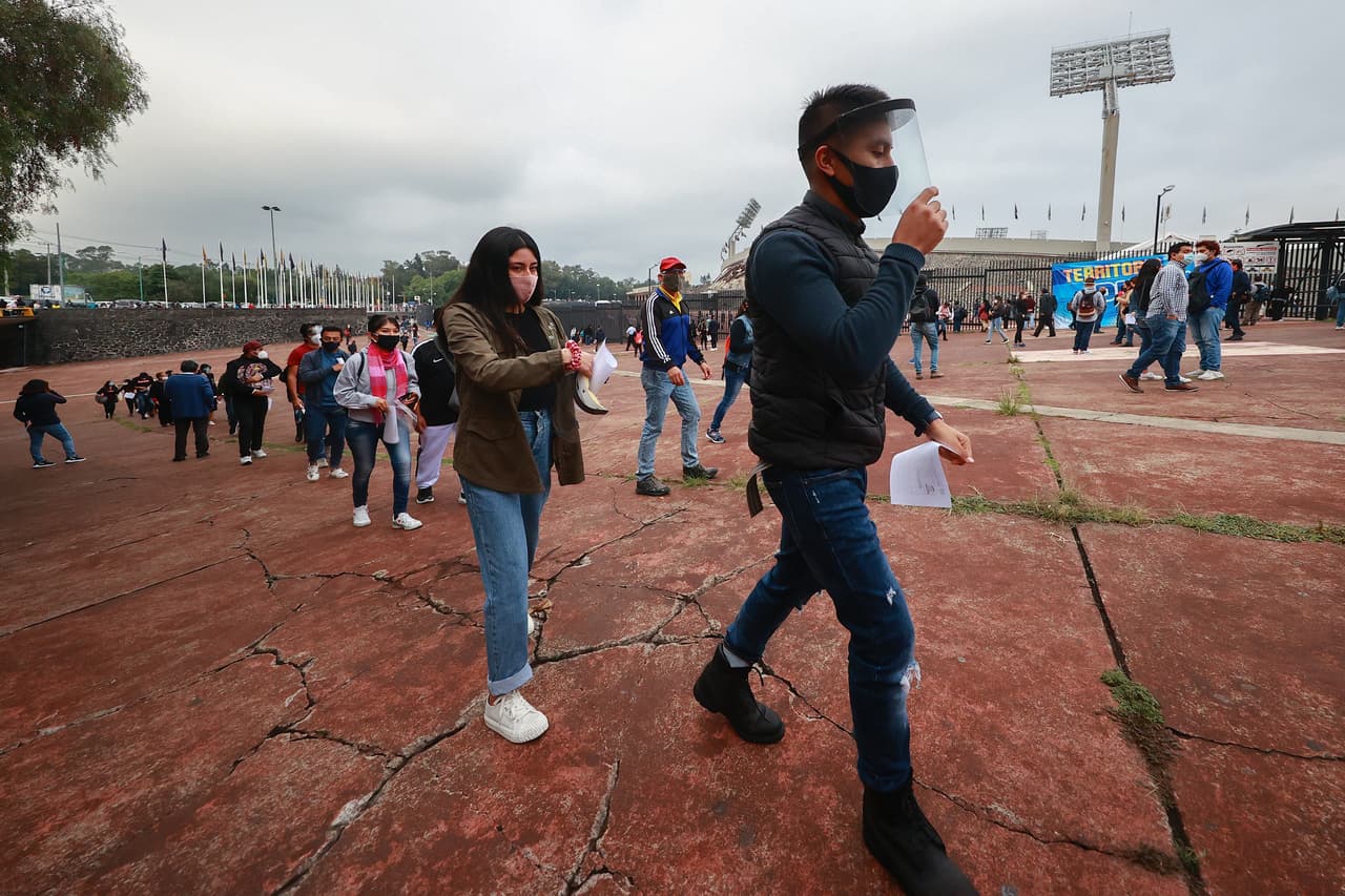 Alumnos con máscaras protectoras mantienen una distancia entre sí durante la fila para ingresar al inmueble. 
<b>A pesar de la ilusión de los estudiantes, de los 84,000 que aplicaron el examen, solo 5,993 serán aceptados.</b>
<br>
<br>