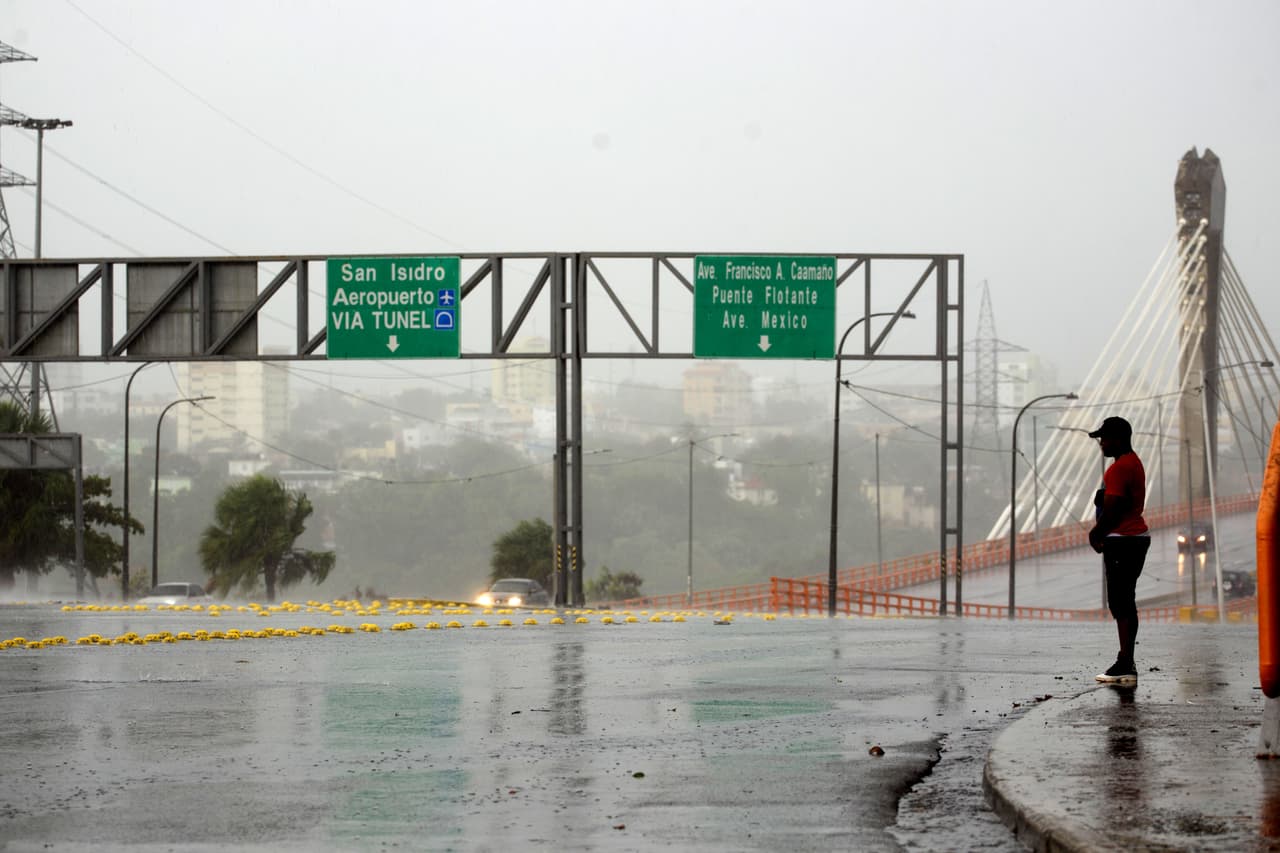 Un hombre bajo la lluvia en el barrio de La Cienaga. Irma tuvo vientos máximos sostenidos de hasta 185 mph (295 km/h), y golpeó en el norte de República Dominicana y Haití el jueves.