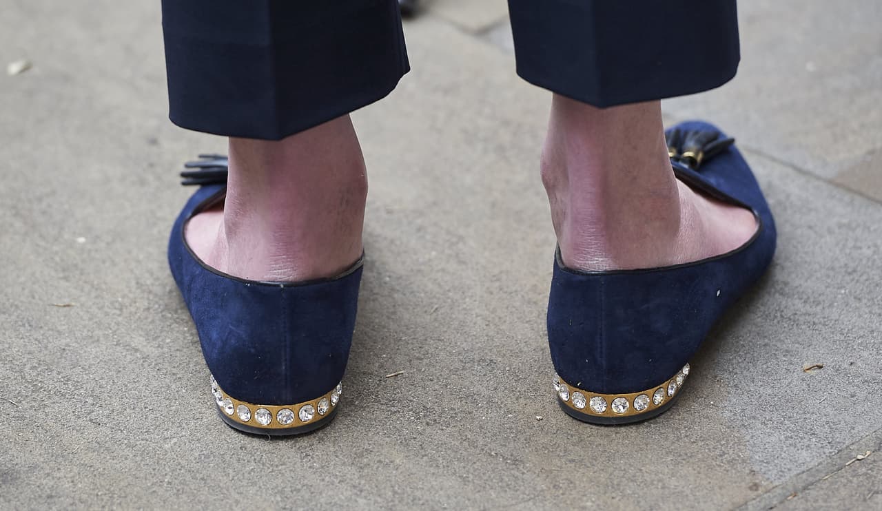 Theresa May sabe cómo hacer que la elegancia y la comodidad comulguen con su estilo de vida. Lo ejemplifican perfecto estos mocasines que aunque adelanten parecen unos zapatos tradicionales, tienen una hilera de brillantes en su discreto tacón. Un toque inesperado de sofisticación.