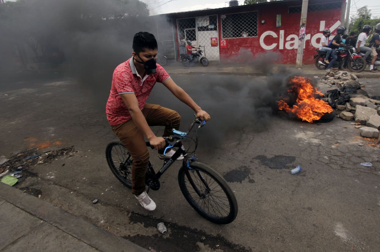 Según dijo Ortega, “existen sectores políticos” que atentan contra la estabilidad del país promoviendo “estos hechos que no tienen nombre”. “Es cierto que hay jóvenes que llegan a protestar por lo que piensan es justo, pero también hay mucha manipulación en las redes sociales”, afirmó. En la fotografía, un hombre monta una bicicleta junto a neumáticos quemados cerca del Colegio Técnico de Nicaragua.