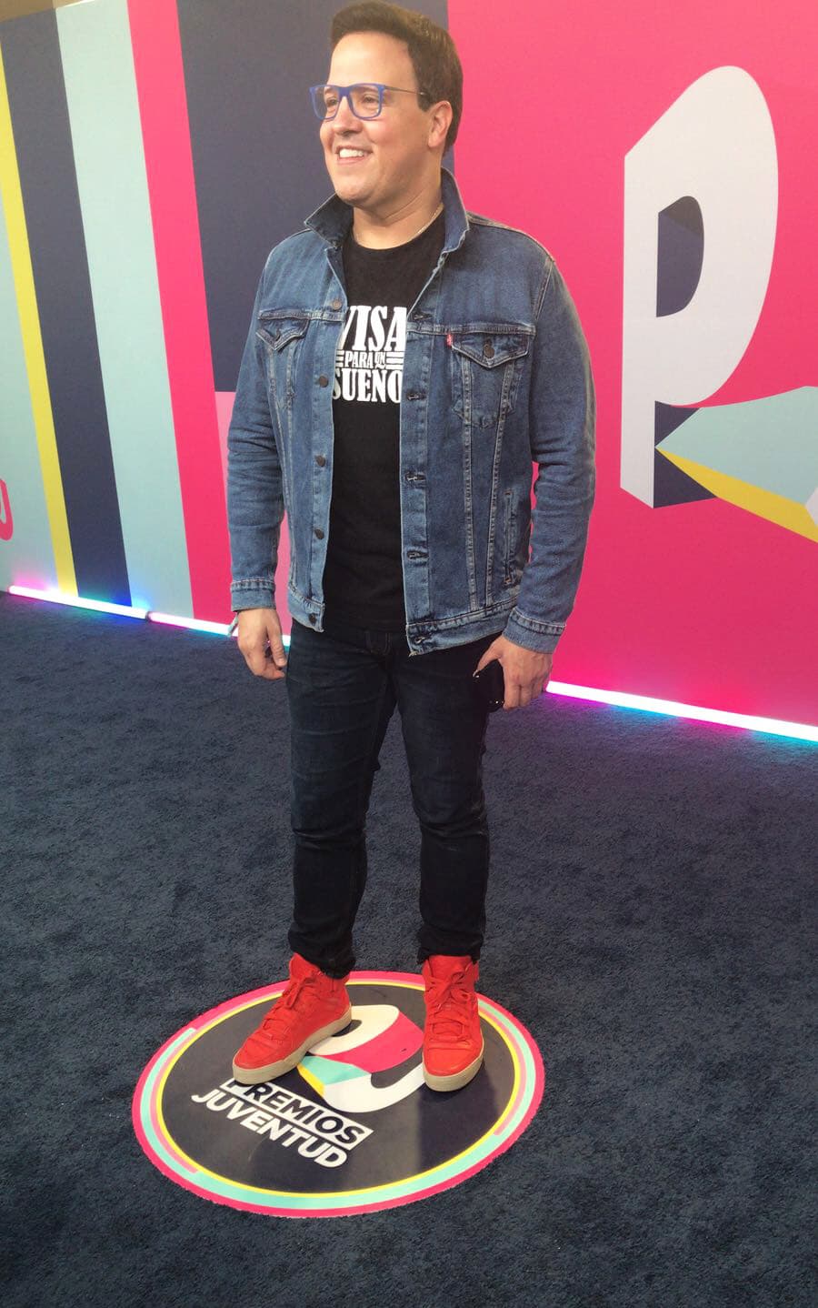 Raúl González optó por un look desenfadado. El conductor de Despierta América vistió pantalones negros, una playera del mismo color, chamara de mezclilla y tenis rojos.