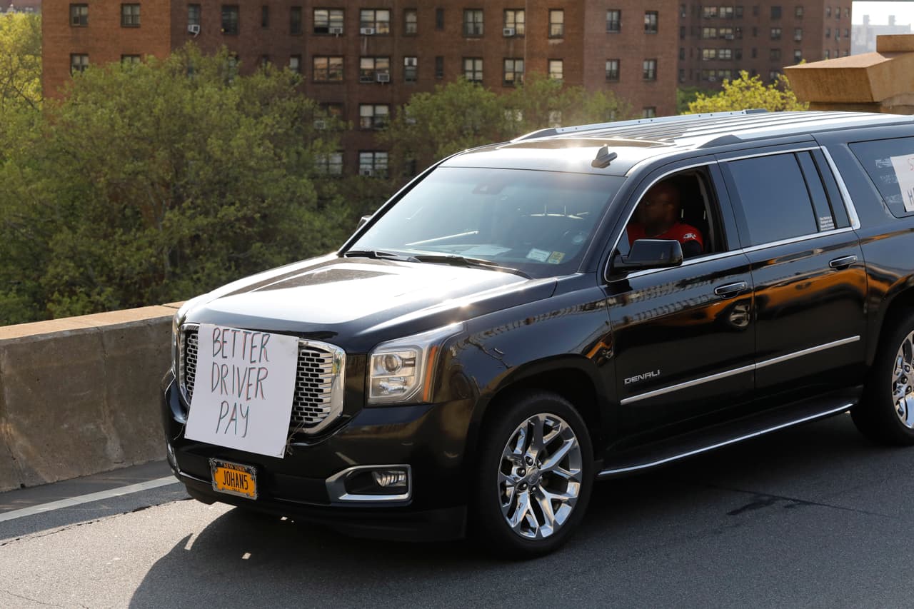 “Mejor pago para los conductores” se lee en el cartel que lleva en la parte frontal un auto de Uber en el puente de Brooklyn, Nueva York.