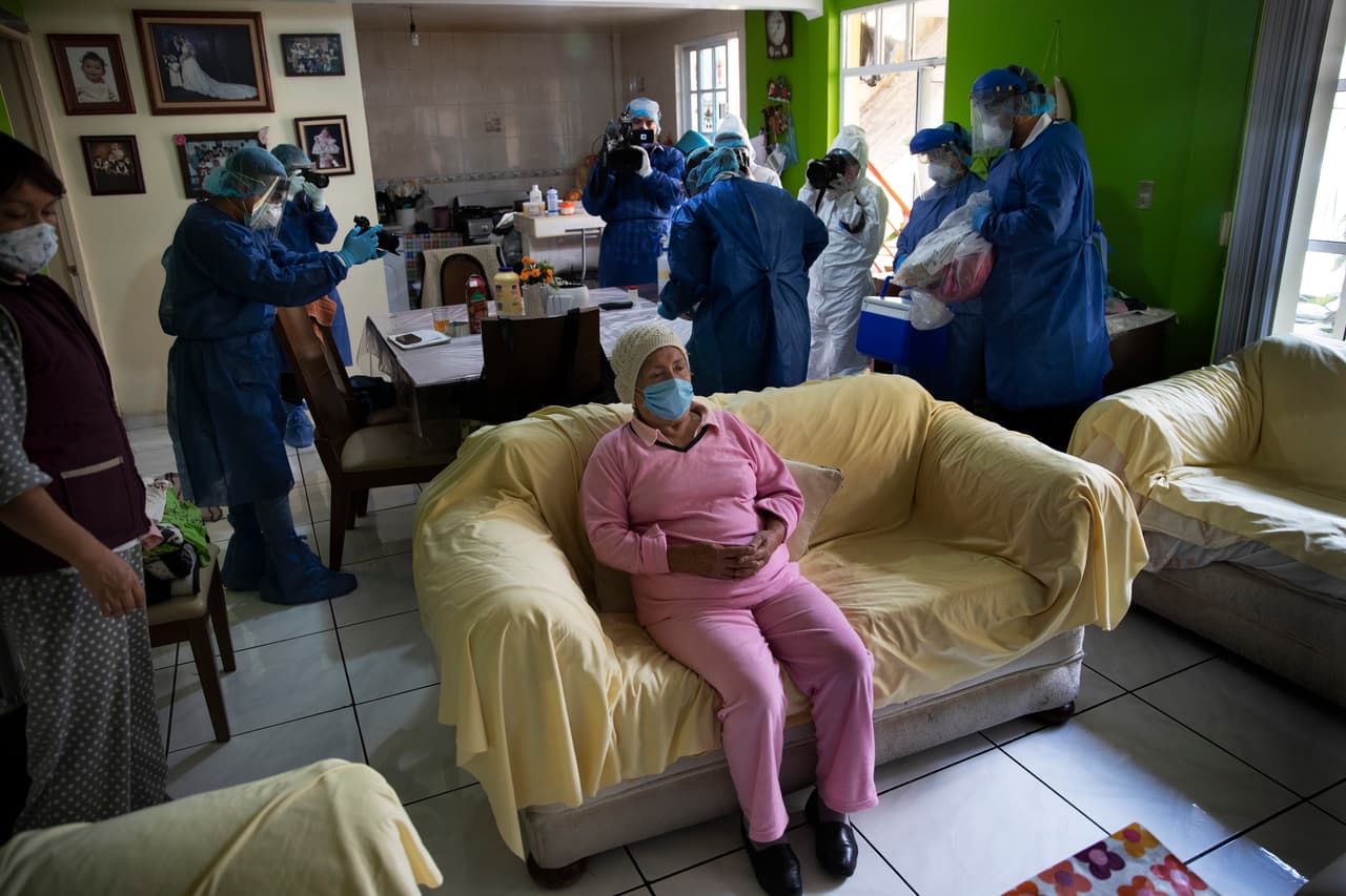 Rebeca Jiménez, de 75 años, espera mientras algunos periodistas registran la preparación de los trabajadores de salud que le harán una prueba de covid-19, el 17 de junio.
<br>
<br>Según los datos presentados por las autoridades de la capital, la mayoría de los fallecidos no registrados dentro de la lista de covid-19 sufría hipertensión, diabetes u obesidad.