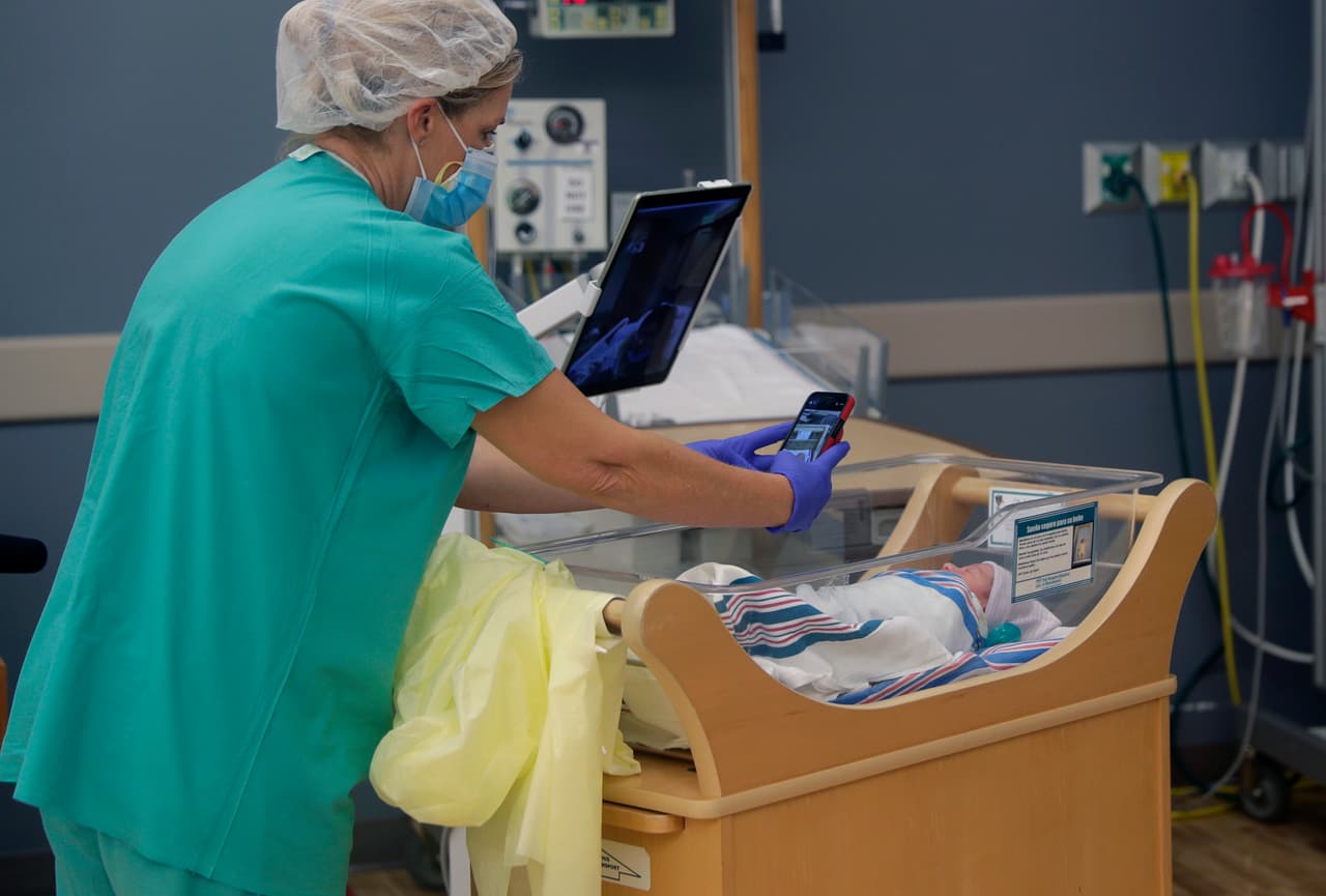 La enfermera Amanda Vaughan toma fotos y ayuda a Clarissa Muñoz, infectada de covid-19, a ver a su bebé desde un iPad en el hospital DHR Health.