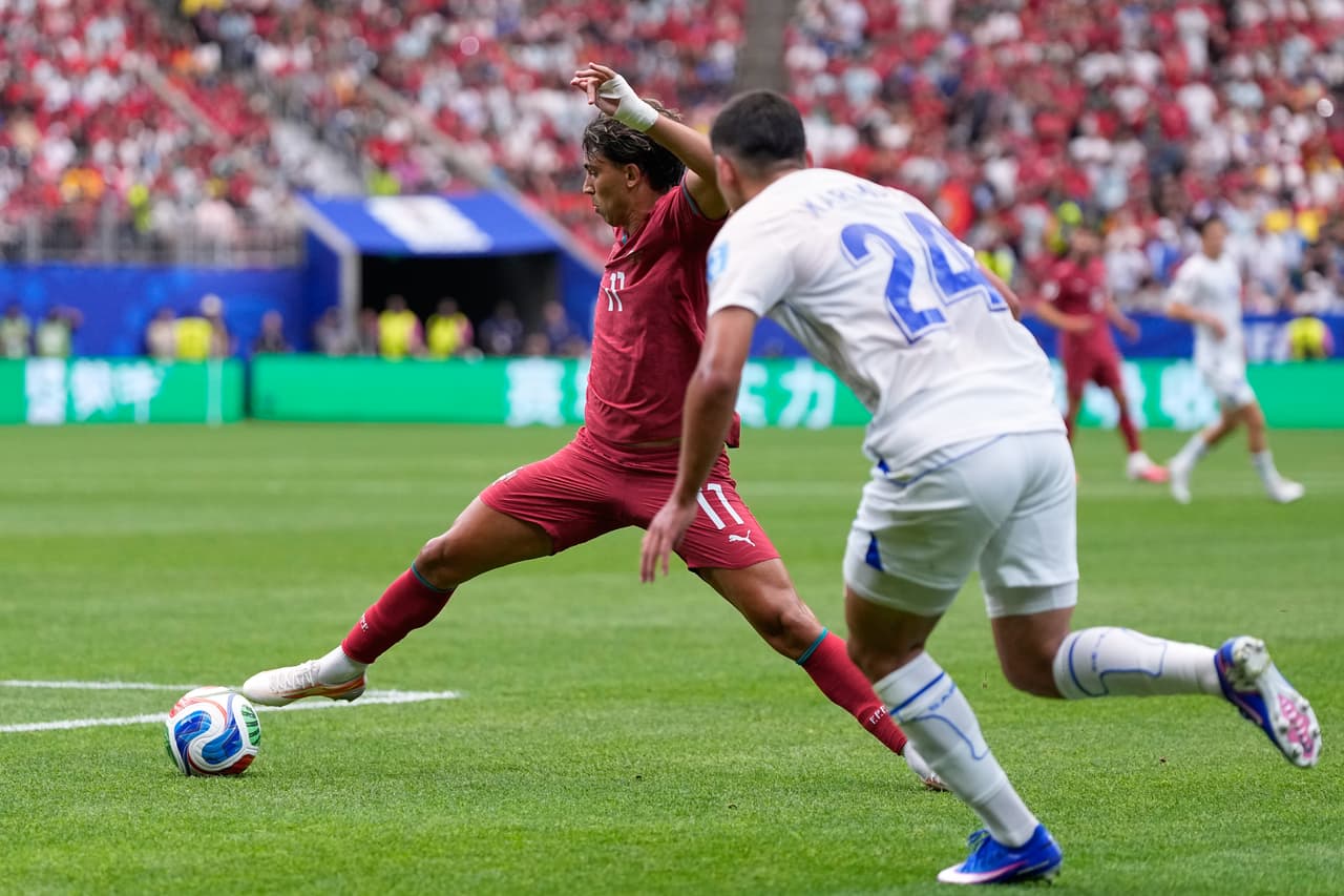 João Félix, de Portugal, intenta alcanzar el balón junto a Behruzjon Karimov, de Uzbekistán (a la derecha), durante el partido de fútbol del Grupo K