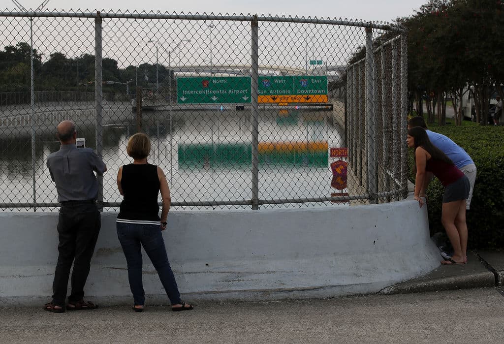 HOUSTON, TX - SEPTEMBER 03: People look at a flooded section of US-90 on September 3, 2017 in Houston, Texas. A week after Hurricane Harvey hit Southern Texas, residents are beginning the long process of recovering from the storm. (Photo by Justin Sullivan/Getty Images)