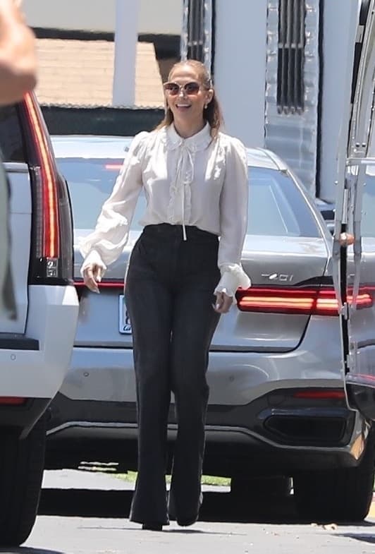 JLo se dejó ver con un top blanco de encaje de manga larga con un par de elegantes pantalones de cintura alta. 
<br>