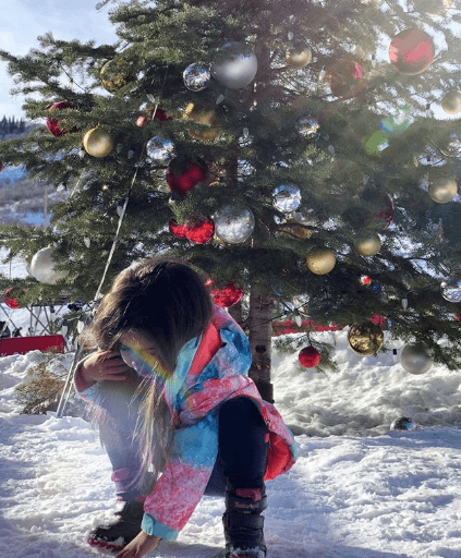 Aitana dejó la aventura a un lado para jugar con la nieve junto a un árbol de navidad.