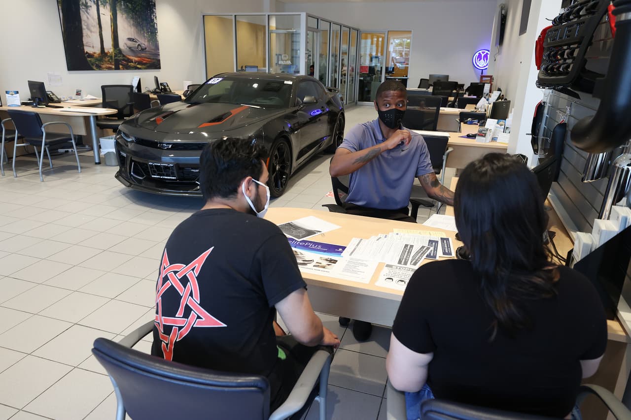 Cheyen Shilletto, un vendedor de coches, habla con sus clientes Julio Larrea y Satima Cruz en East Hills Chevrolet.
