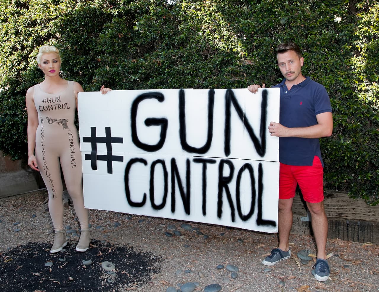 Sasha Gradiva y ChadMichael Morrisette muestran un cartel para pedir más control de armas. La sesión fotográfica tuvo lugar el 12 de julio, un mes después del ataque en Orlando.