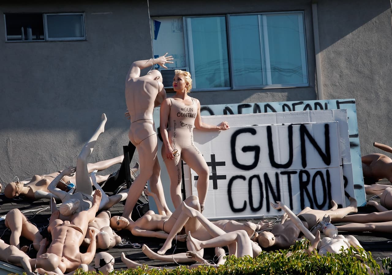 La cantante Sasha Gradiva luce un mono color carne, simulando el aspecto de un maniquí. En esa prenda lleva dibujada una pistola con el cañón anudado y los mensajes "Gun Control", "Black Lives Matter" y "Disarm Hate".
