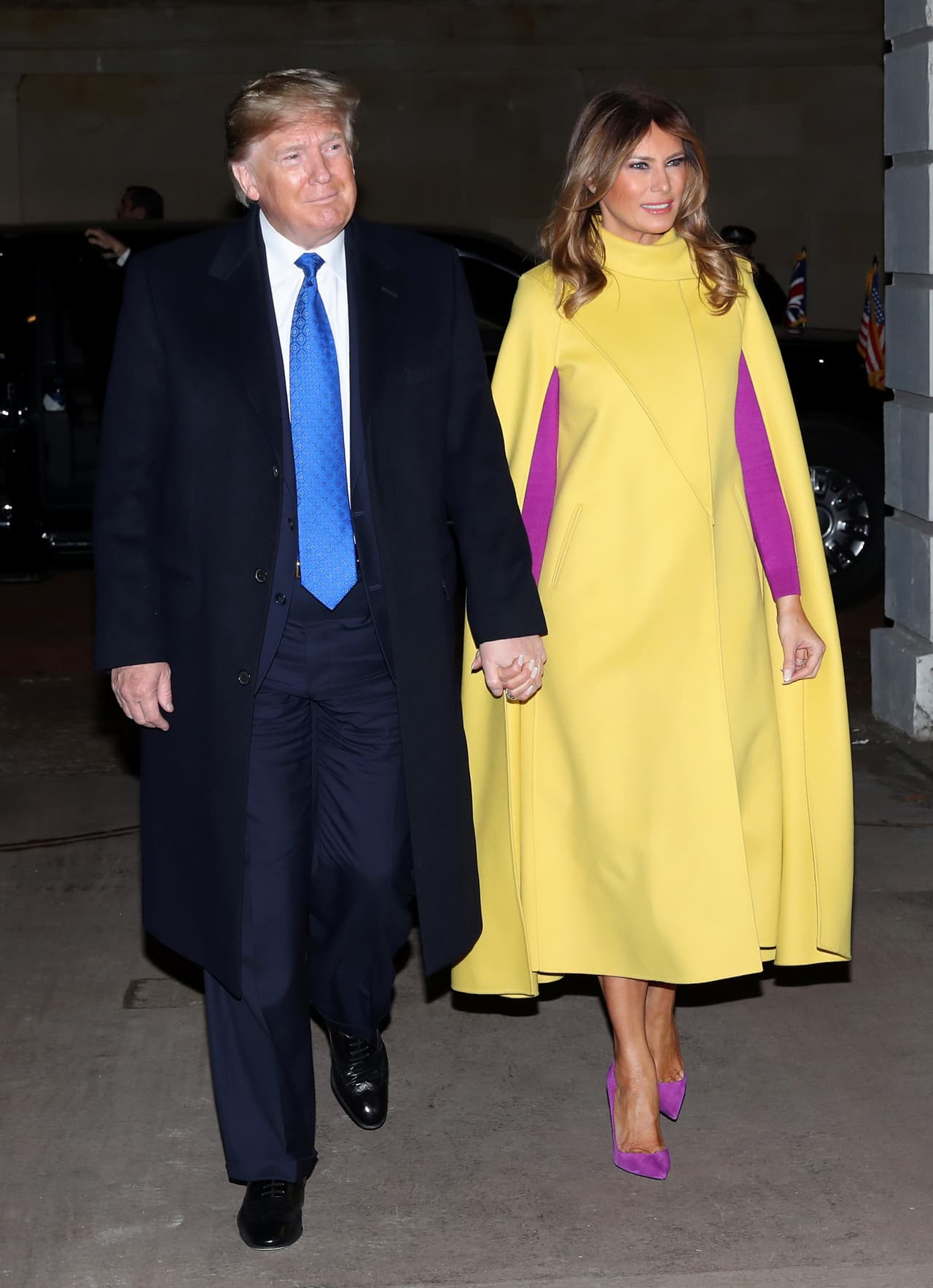 Melania Trump combinó su capa con un vestido color magenta.