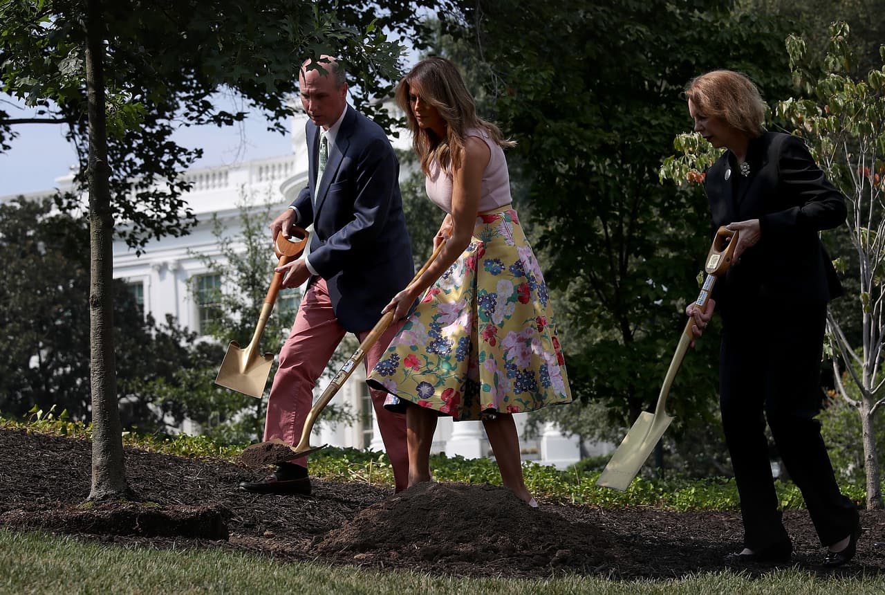 WASHINGTON, DC - AUGUST 27: U.S. first lady Melania Trump (C) takes part in a tree planting ceremony on the south grounds of the White House August 27, 2018 in Washington, DC. The tree comes from the original Eisenhower Oak located near the Kennedy Garden that was excavated from the grounds earlier this year. Joining the first lady is Mary Jean Eisenhower (R), granddaughter of President Dwight Eisenhower and Richard Gatchell Jr. (L), fifth generation grandson of President James Monroe. (Photo by Win McNamee/Getty Images)
