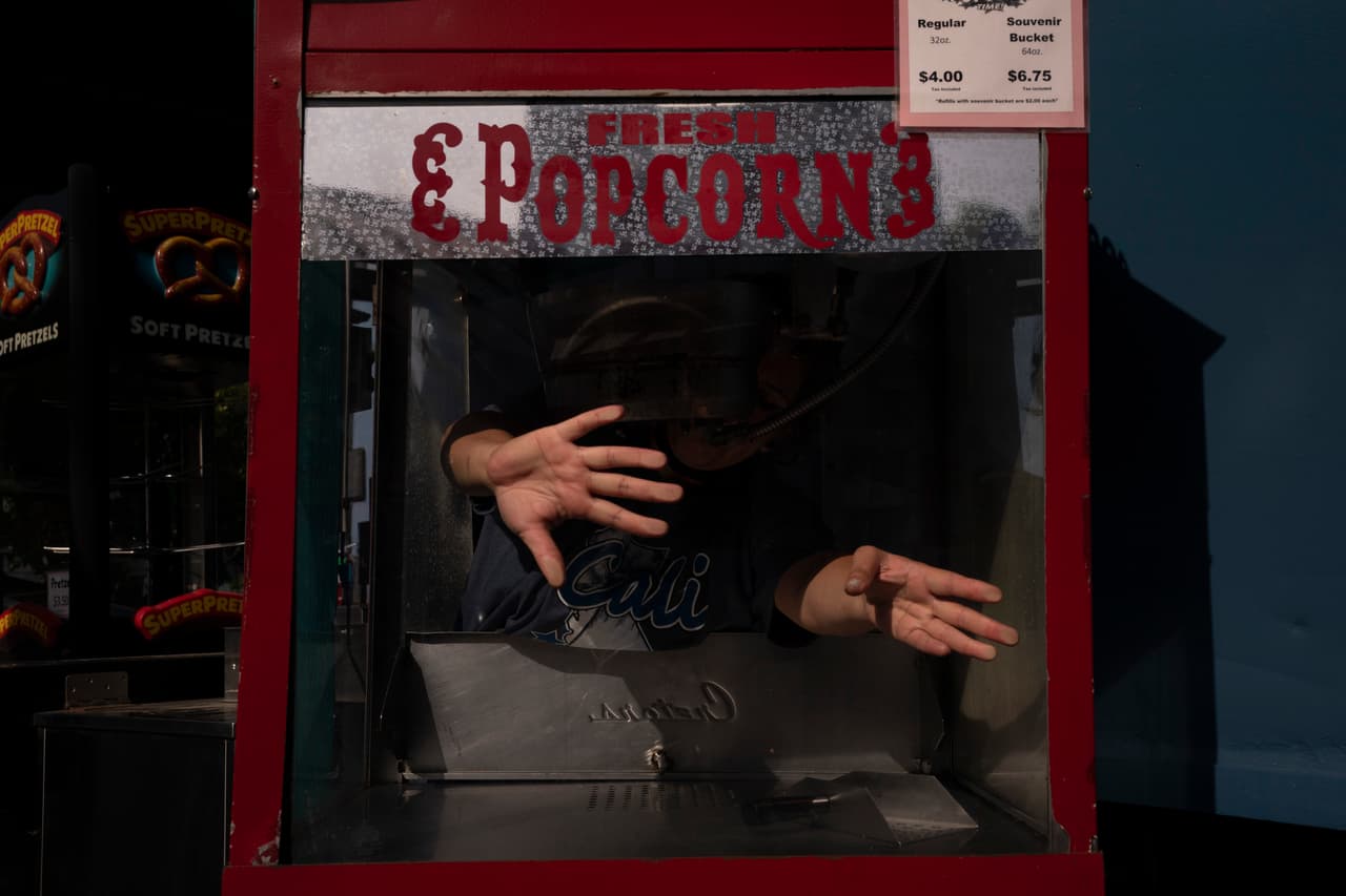 Sandy Martinez, de 32 años, alista una máquina de palomitas de maíz en el parque de diversiones Adventure City. Martínez es una de las trabajadoras que volvió un año después de que el sitio cerrara sus puertas debido a la pandemia. "No quise buscar otra opción de trabajo porque me encanta trabajar aquí", dijo Martínez, quien comenzó a laborar ahí desde que tenía 18 años. "Son como mi familia".
<br>