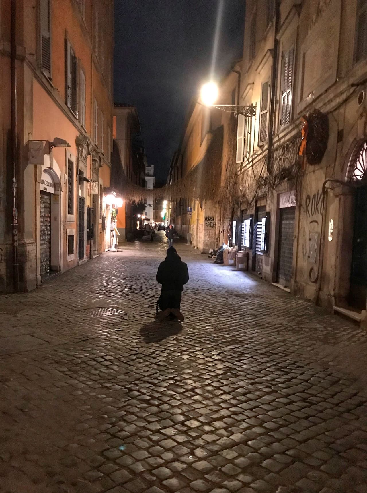 Un mendigo en la calle della Longaretta en Trastevere, Roma, una vía que normalmente está llena de turistas. Un silencio completo reinaba en Trastevere, el barrio de "la movida" de la capital italiana, que amaneció con bares y restaurantes cerrados, las calles desiertas y la gente encerrada en sus casas.