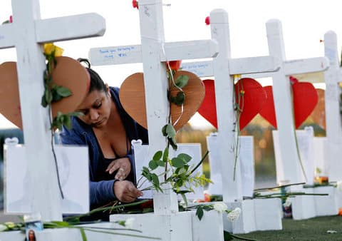 En esta imagen se puede ver a Cece Navarrete colocando flores en la cruz de su prima Bailey Schweitzer, quien se encuentra entre las víctimas fatales.