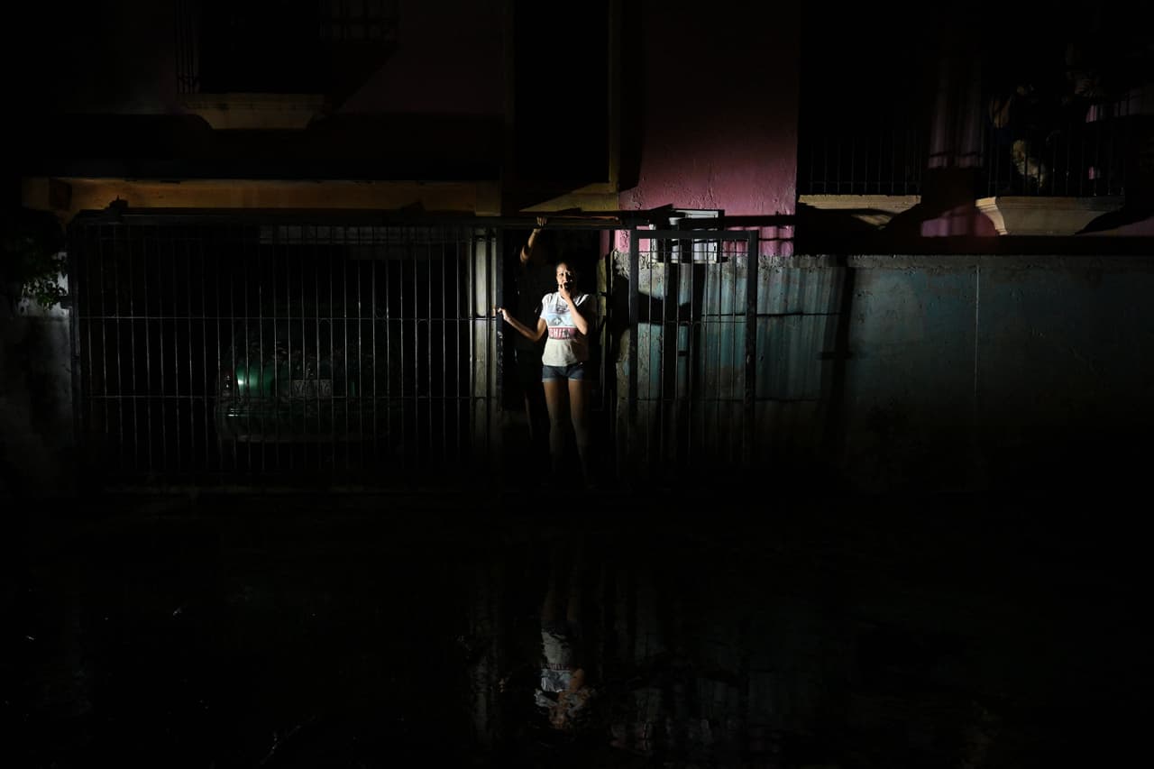 Un equipo de la AFP constató la situación provocada por el desbordamiento del río El Palmarito tras horas de intensas precipitaciones hacia la parte alta de la montaña. Una mujer en las afueras de su casa inundada en El Castaño.