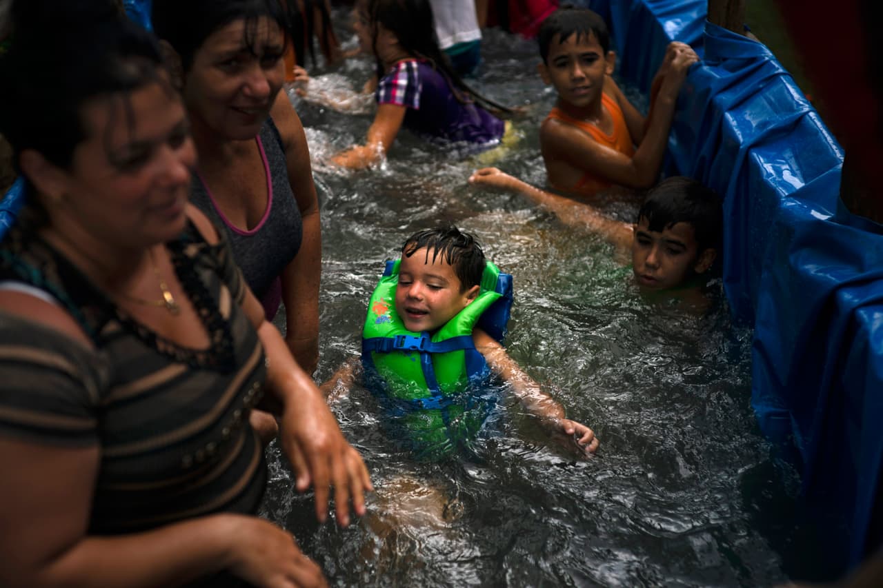 La idea de la piscina en el tractor se le ocurrió a los padres de familia Mariset Martínez y Yamian Válido el pasado 26 de julio durante la fiesta nacional. Querían hacer a sus hijos felices y combatir el duro calor caribeño en una comunidad que hace honor a su nombre.