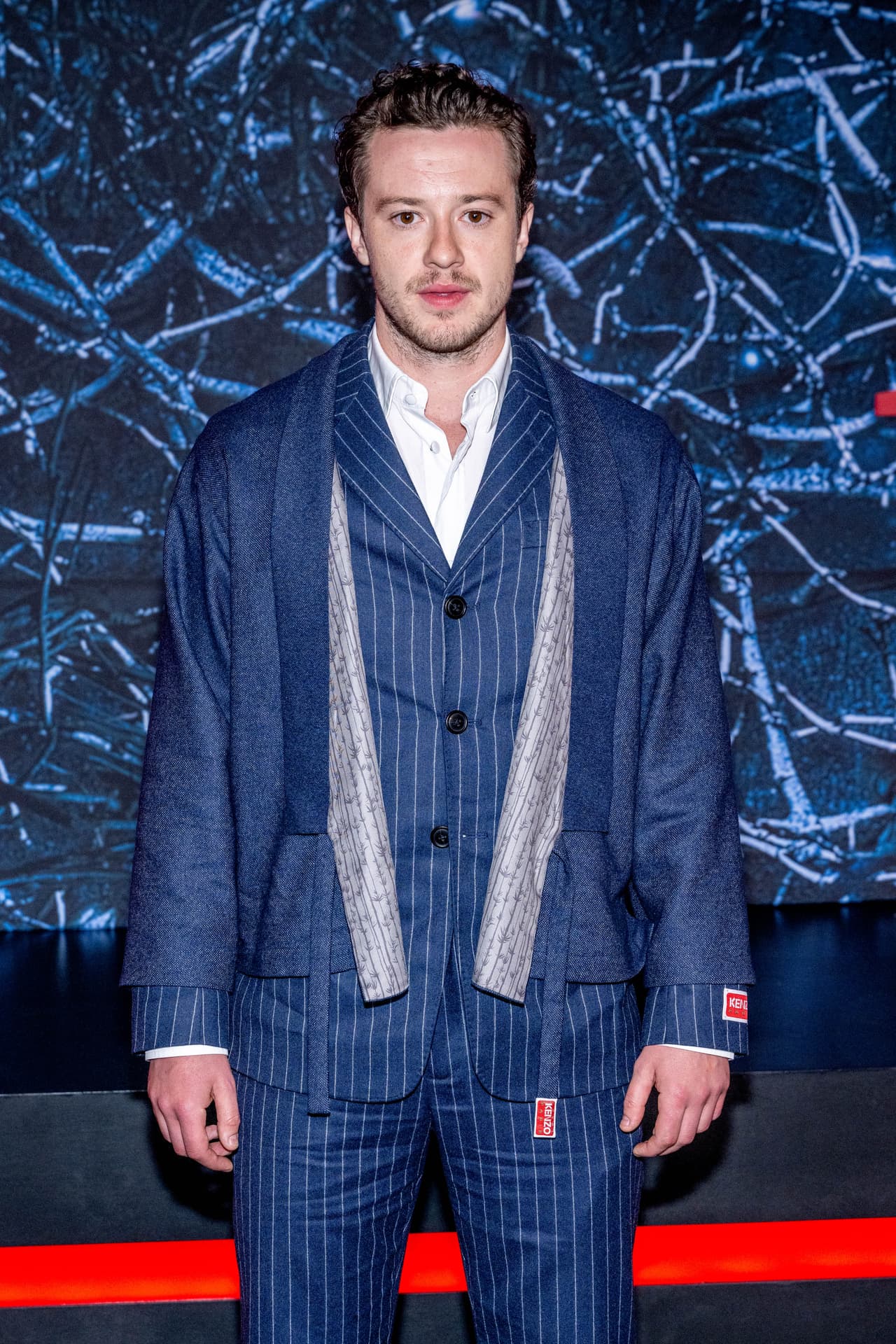 El aspecto del actor de 29 años dista bastante de su look como Eddie, ya que el pelo largo y ondulado no forma parte de su semblante.