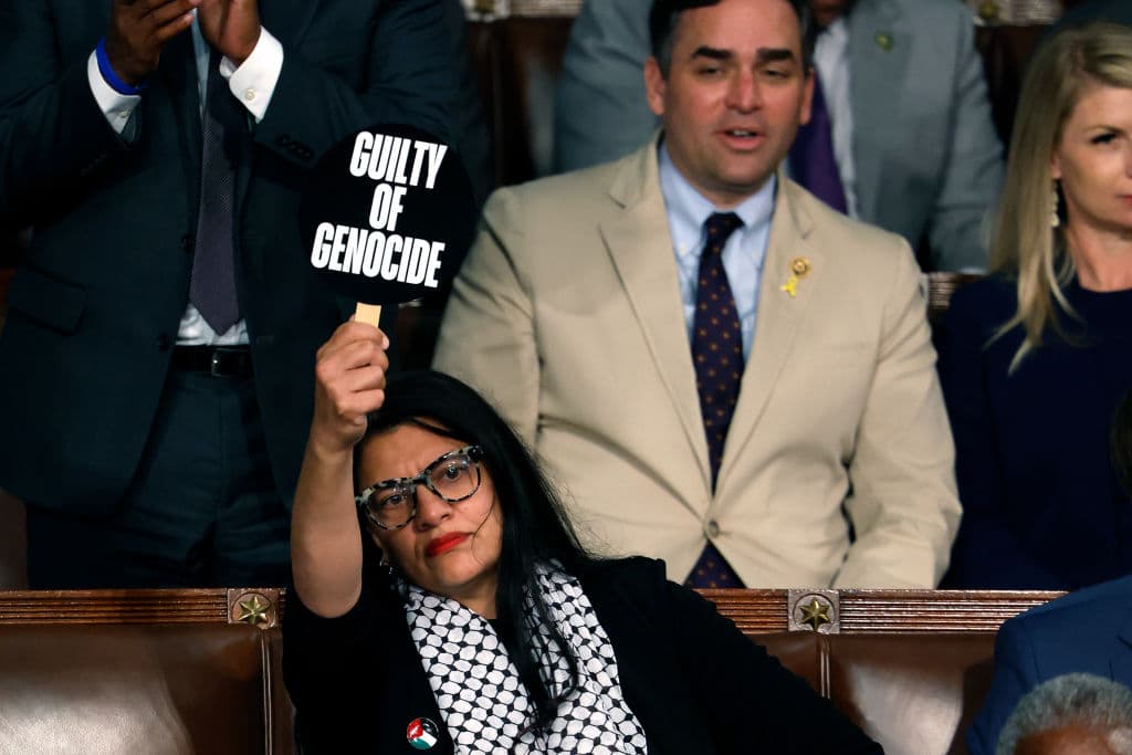 La representante Rashida Tlaib (demócrata por Michigan) sostiene un cartel que dice "Culpable de genocidio" mientras el primer ministro israelí, Benjamin Netanyahu, se dirige al Congreso.