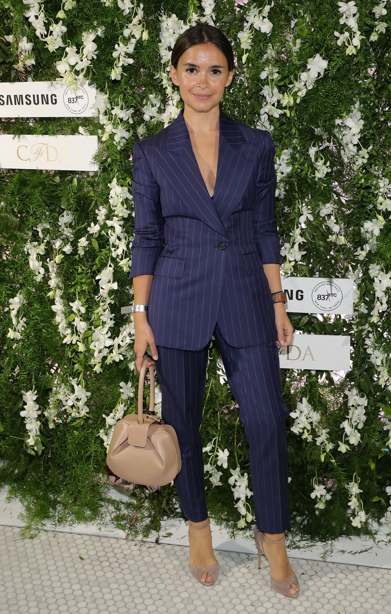 Sin complicarse mucho por hacer una verdadera declaración sobre la alfombra roja, la millonaria rusa y bloguera de moda Miroslava Duma usó un tradicional sastre azul oscuro de raya de tiza con unos zapatos 'nude'. Una reafirmación más de que todas deberían tener en su armario un 'suit' masculino que lo puedan llevar para el trabajo o para una alfombra roja.