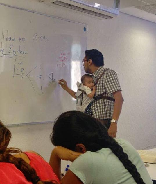 Profesor cargando a bebé en clase