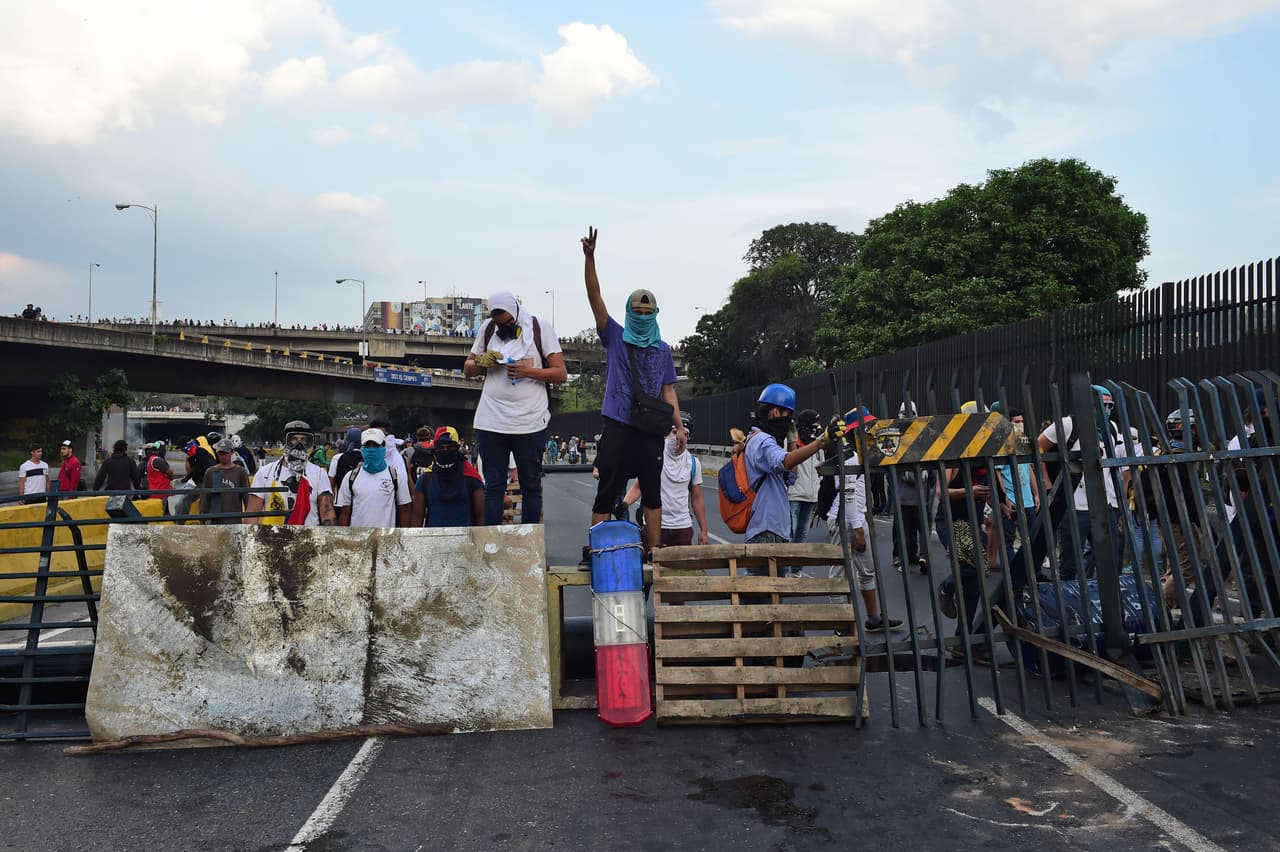 Opposition barricades with metal railings, mattresses and wooden crates.