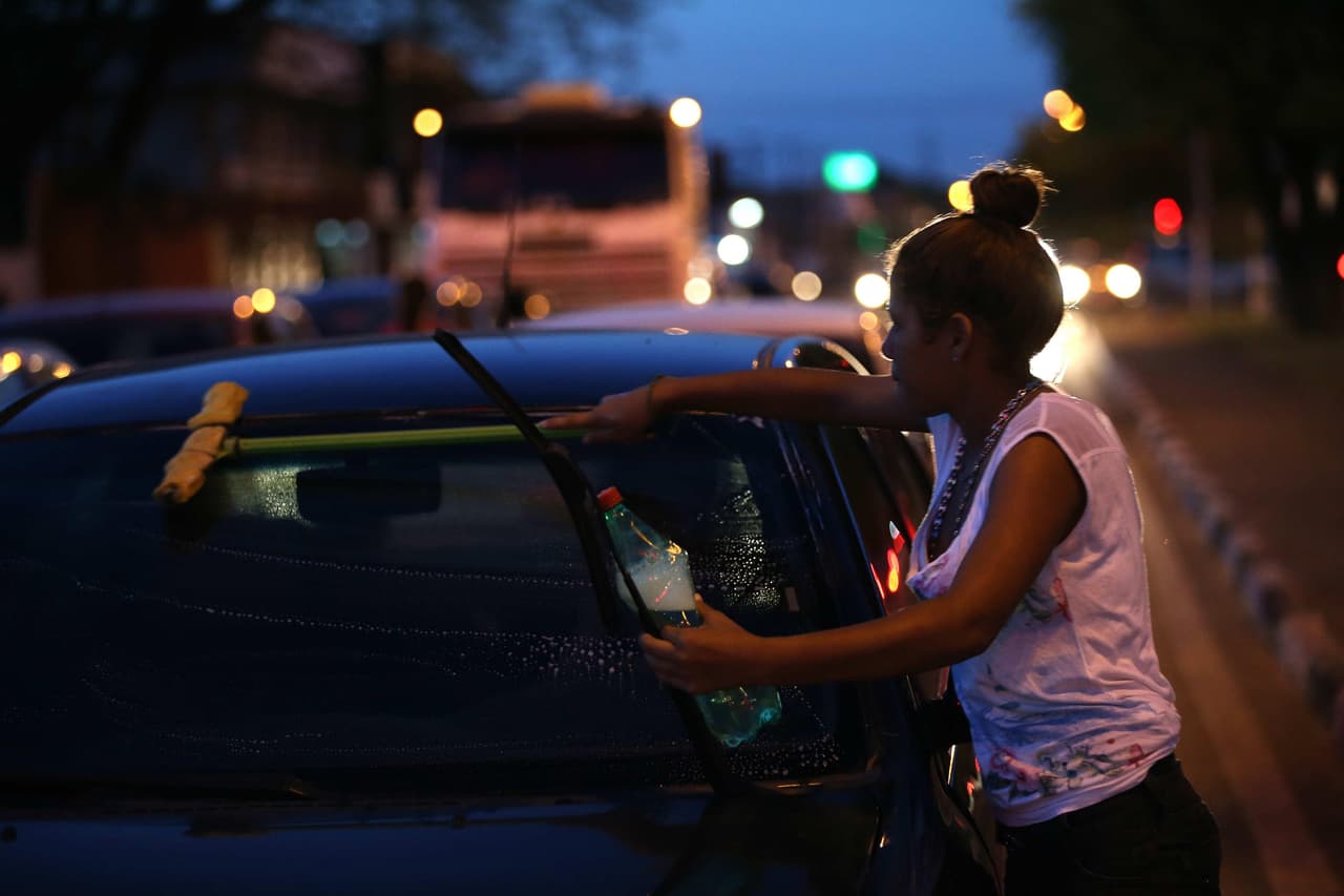 ACOMPAÑA CRÓNICA: BRASIL VENEZUELA. BRA16. BOA VISTA (BRASIL), 22/10/2016.- Una joven venezolana limpia el parabrisas de un automóvil este jueves, 22 de octubre de 2016, en la esquina de la calle Mario Homem de Melo y la avenida Venezuela, en Boa Vista, estado de Roraima (Brasil). Sea para vender baratijas, limpiar los parabrisas de los automóviles o mendigar, los venezolanos se han apropiado de los semáforos de la ciudad brasileña de Boa Vista, en los que hacen múltiples trabajos por unas pocas monedas. EFE/Marcelo Sayão