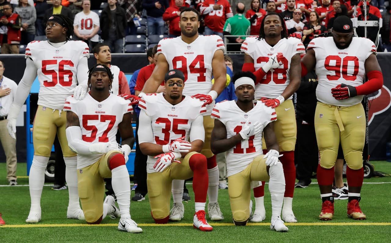 FILE - In this Dec. 10, 2017, file photo, San Francisco 49ers San Francisco 49ers' Eli Harold (57), Eric Reid (35) and Marquise Goodwin (11) kneel during the national anthem before an NFL football game against the Houston Texans, in Houston. President Donald Trump's feud with the NFL about players kneeling during the national anthem is the runaway winner for the top sports story of 2017 in balloting by AP members and editors. (AP Photo/David J. Phillip, File)