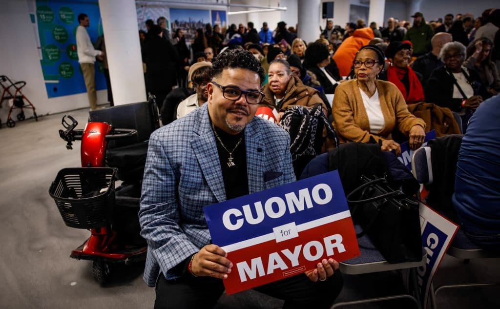 Manifestantes a favor sostienen carteles mientras esperan al candidato a la alcaldía de la ciudad de Nueva York, Andrew Cuomo.