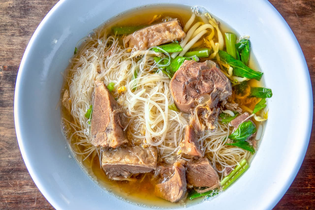 <b>Sopa de fideos con ternera Lanzhou</b>
<br>
<br>
<b>Origen: China</b>
<br>
<br>Exquisitos fideos hechos a mano se cocinan en un tazón de caldo de res tierna, con rodajas de rábano pálido, aceite de chile y hierbas frescas.
<br>
<br>La preparación de estos fideos es parte de una tradición milenaria china. La masa de trigo finamente molido se tuerce, estira y dobla para formar hebras, usando su propio peso.
<br>