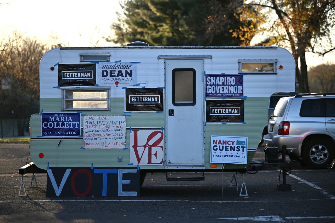 Pancartas políticas se exhiben al costado de una caravana en un estacionamiento en un colegio electoral en Bryn Athyn, Pensilvania, durante las elecciones de mitad de período de EE. UU. El 8 de noviembre de 2022.