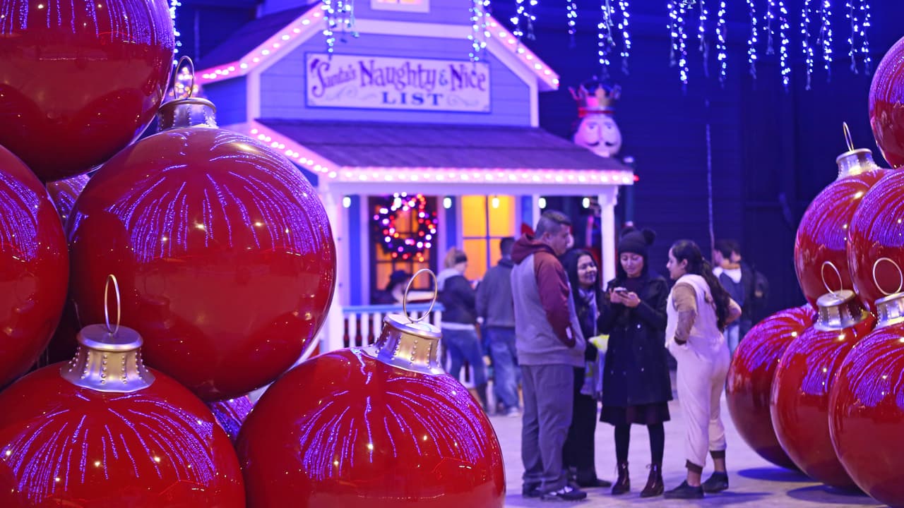 Las familias esperan a sus niños que van a visitar al duende Tinsel para descubrir si están en la lista de los bien portados o en la de los groseros.