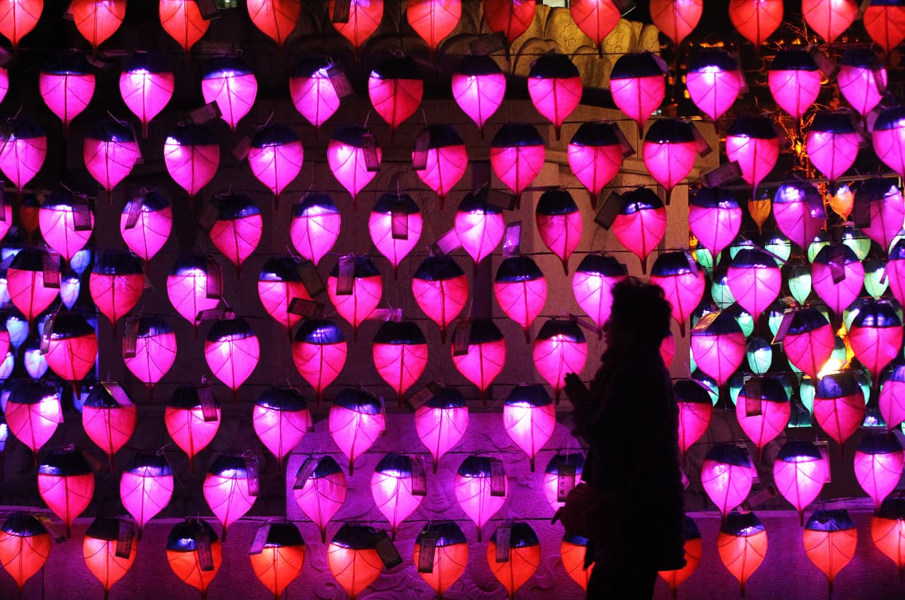 Una mujer reza enfrente de linternas para celebrar el Año Nuevo en el Templo Budista Chogye en Seúl.