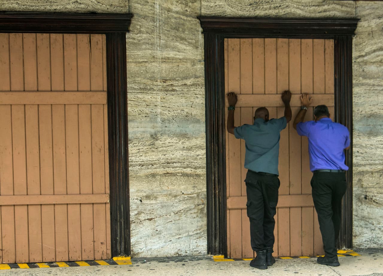 Barbados, en el extremo oriental del mar Caribe, es la primera isla en el camino de Dorian. El lunes en la noche fue golpeada por fuertes vientos, lluvias intermitentes, truenos y relámpagos. En la fotografía, residentes de Speightstown protegen sus ventanas ante la inminente llegada de la tormenta.