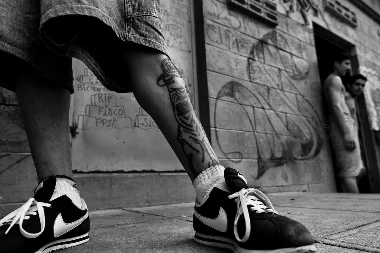 TONACATEPEQUE, EL SALVADOR - MAY 18: A member of the Mara Salvatrucha gang (MS-13) stands in front of his cell in the prison of Tonacatepeque, on May 18, 2011 in Tonacatepeque, El Salvador. During the last two decades, Central America has become the deadliest region in the world that is not at war. According to the UN statistics, more people per capita were killed in El Salvador than in Iraq, in recent years. Due to the criminal activities of Mara Salvatrucha (MS-13) and 18th Street Gang (M-18), the two major street gangs in El Salvador, the country has fallen into the spiral of fear, violence and death. Thousands of Mara gang members, both on the streets or in the overcrowded prisons, organize and run extortions, distribution of drugs and kidnappings. Tattooed armed young men, mainly from the poorest neighborhoods, fight unmerciful turf battles with their coevals from the rival gang, balancing between life and death every day. Twenty years after the devastating civil war, a social war has paralyzed the nation of El Salvador. (Photo by Jan Sochor/Latincontent/Getty Images)
