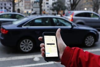 Un cliente pide un UBER desde la aplicación en su teléfono celular. 