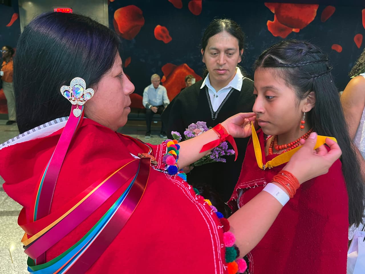 Mirian Masaquiza ayuda a su hija a vestirse. El esposo de Mirian observa. La pareja fue una de las 700 que participaron en la boda masiva efectuada en el Linconl Center.