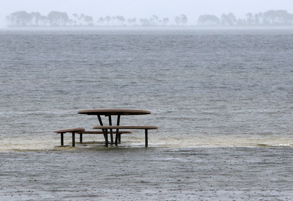 Una mesa de picnic rodeada por las aguas del mar en la base aérea de Tyndall, en Panama City, Florida