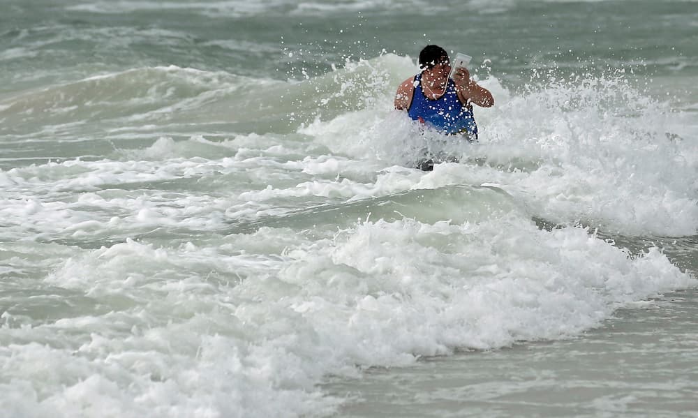 Algunos osados, como este hombre, aprovecharon el fuerte oleaje que dejó la tormenta para surfear.