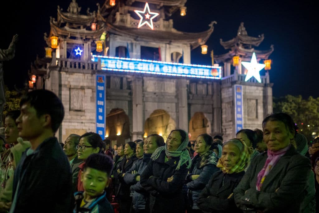 Peregrinos participan en la procesión del niño Jesús liderada por el obispo Joseph Nguyen Nang en la misa de Nochebuena en la catedral de Phat Diem, en la provincia de Ninh Binh.