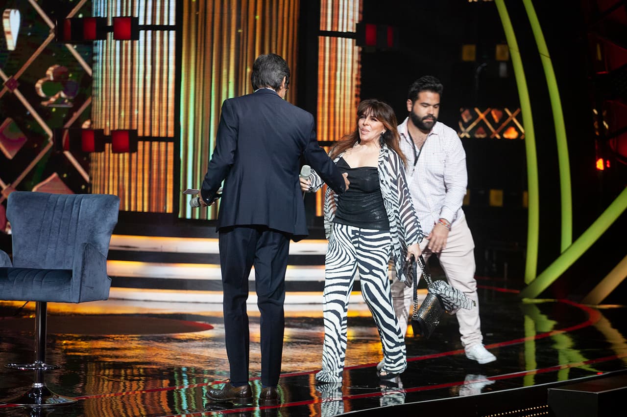 Enfundada en un traje con estampado de cebra y un top negro, 'La Vero', asistida por un elemento de la producción, subió al escenario con su —ahora lo sabemos— inseparable bolsa Chanel.