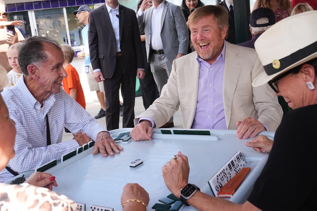 El rey Guillermo sonríe al inicio de una ronda de dominó.