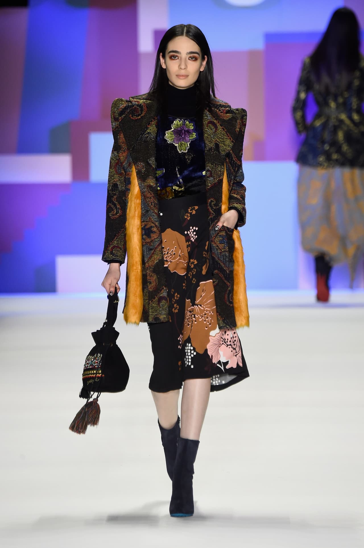 Un abrigo de patchwork ( es decir, hecho de retazos), un vestido de flores y una pequeña mochila es el look que los diseñadores de Desigual han elegido para ella.