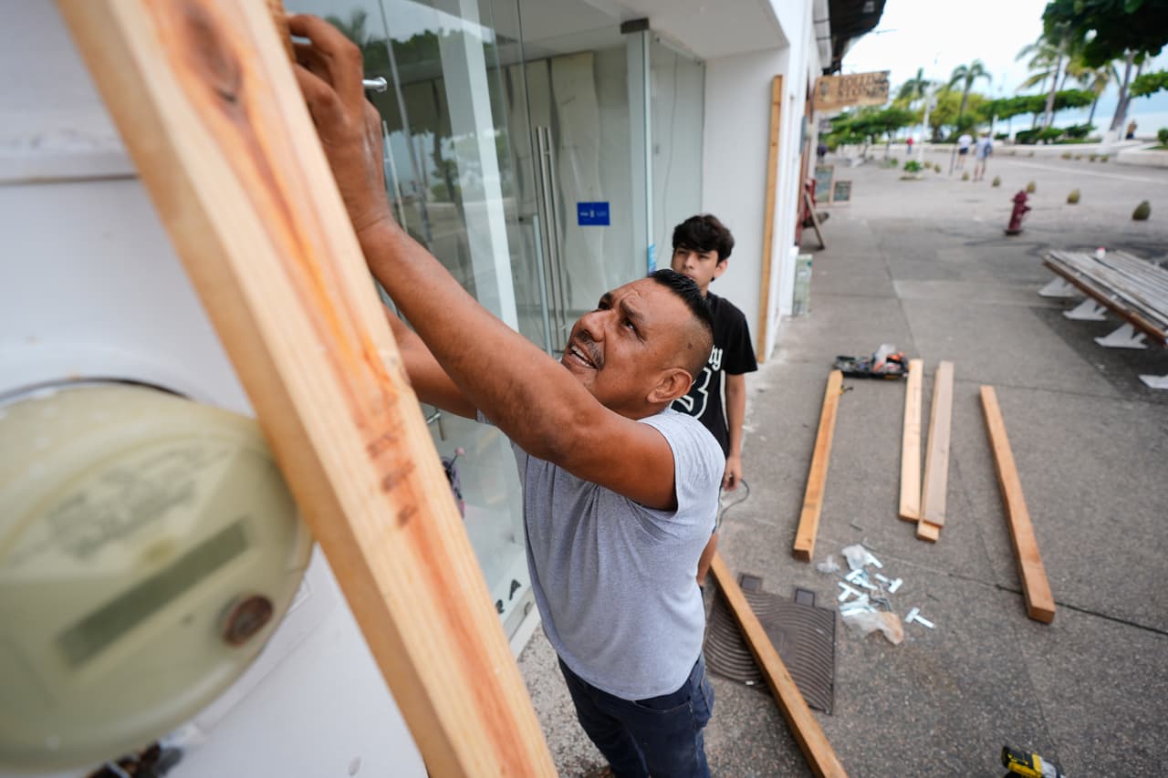 Un hombre tapia una tienda mientras el huracán Simón se acerca a Puerto Vallarta, México, el sábado 10 de octubre de 2026.